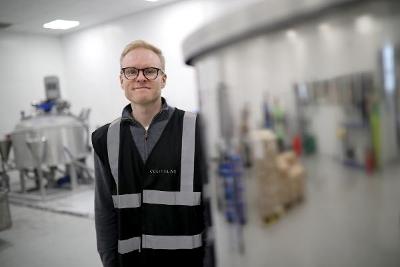 A man standing next to equipment in Whitewash Labs.