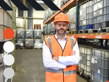 Man working in hard hat and a high visibility jacket in a warehouse.