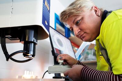 Woman at Icon Plastics looks at microscope equipment