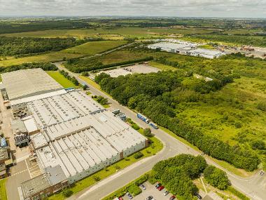 Drone image of Durham Lane Industrial Park showing warehouses and green and wooded areas