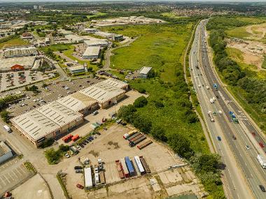 Drone image showing available land at Portrack Lane with warehouses and green space