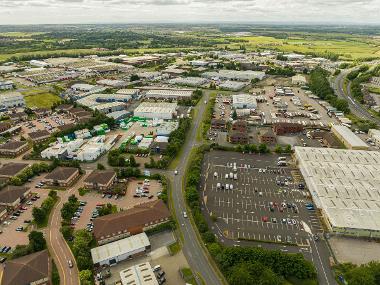 Drone image of Preston Farm showing Falcon Court, a car park, warehouses and other buildings